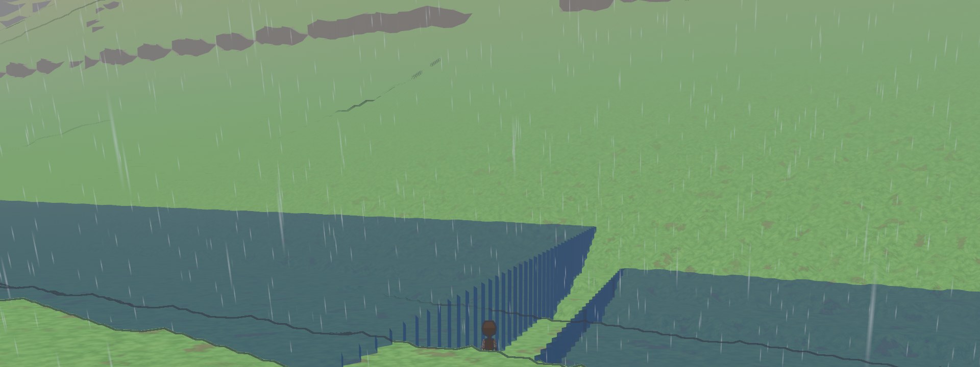 A broad lake that ends in a straight wall of water standing above the grass, in the rain